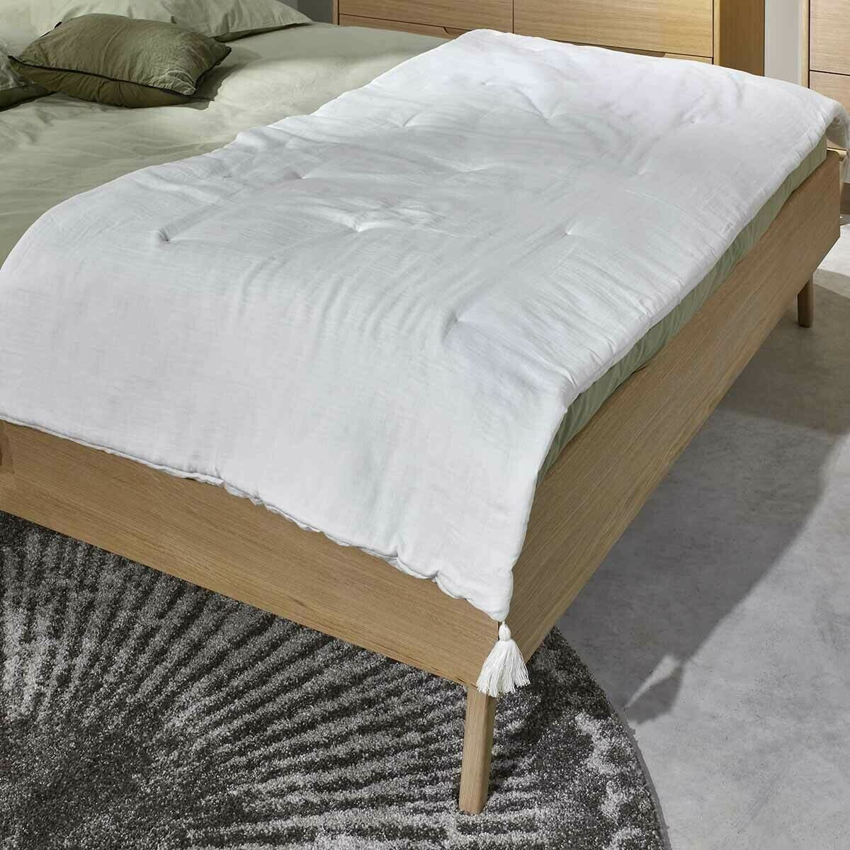 Edredon en gaze de coton blanc sur lit 